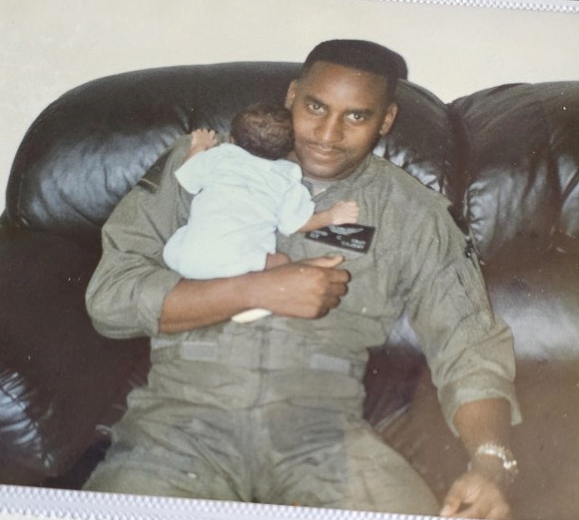 David Grey in flight suit holding his infant son, Dothan, Alabama, 1991